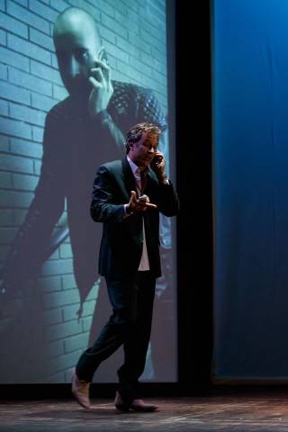 Paolo Romano attore recita teatro al telefono sfondo proiezione